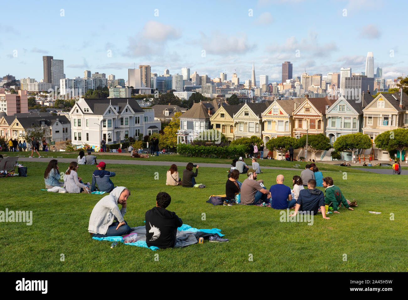 SAN FRANCISCO, Stati Uniti d'America - 8 Settembre 2019 : Persone rilassante in Alamo Square Park su una calda giornata con una vista del famoso dipinto di onorevoli skyline della città Foto Stock