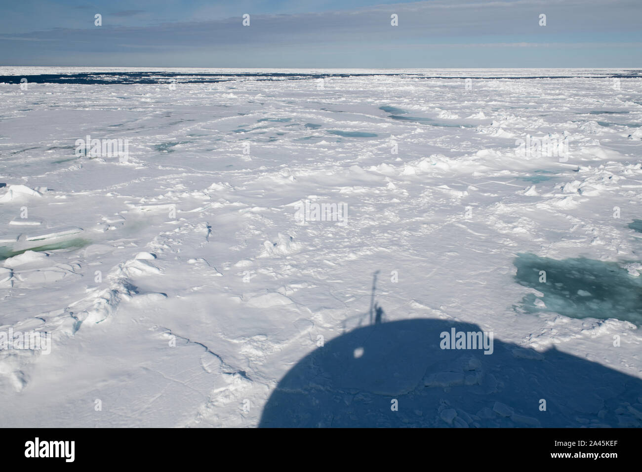 La Russia, alta artico, Franz Josef Land. Rudolf isola. Capo Fligely aka Tegetthoff del capo. Ombra di icebreaker andando attraverso il ghiaccio. Foto Stock