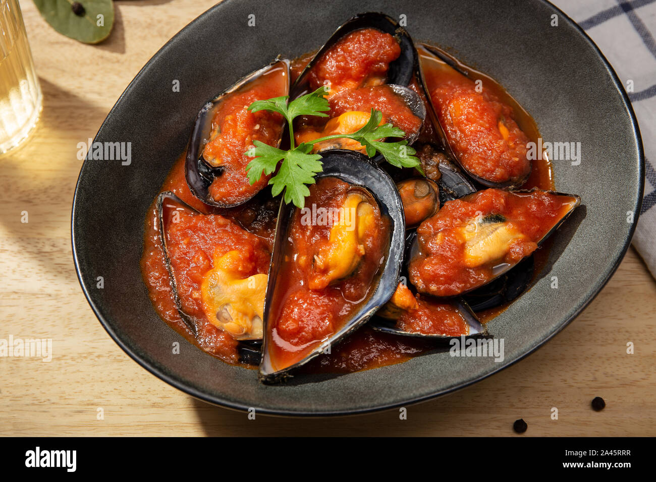 Cuocere le cozze. Le cozze al vapore caldo con salsa speziata. Gustosi piatti di pesce spagnolo ricetta. Vista superiore Foto Stock