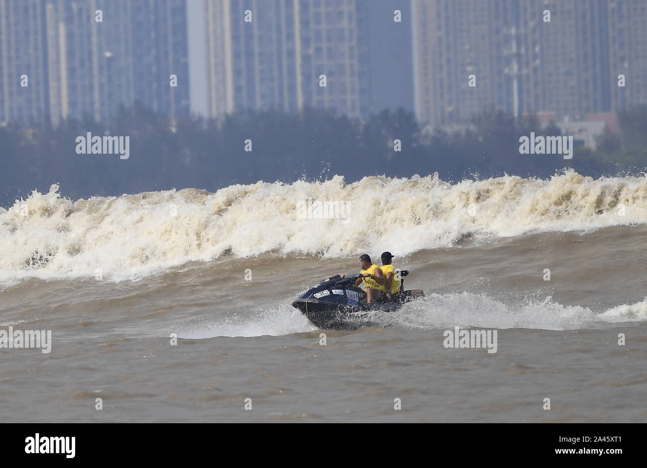 Surfisti cavalcare un onda sul Fiume Qiantang in Hangzhou, Oriente Cina¯s nella provincia di Zhejiang, 16 settembre 2019. Foto Stock