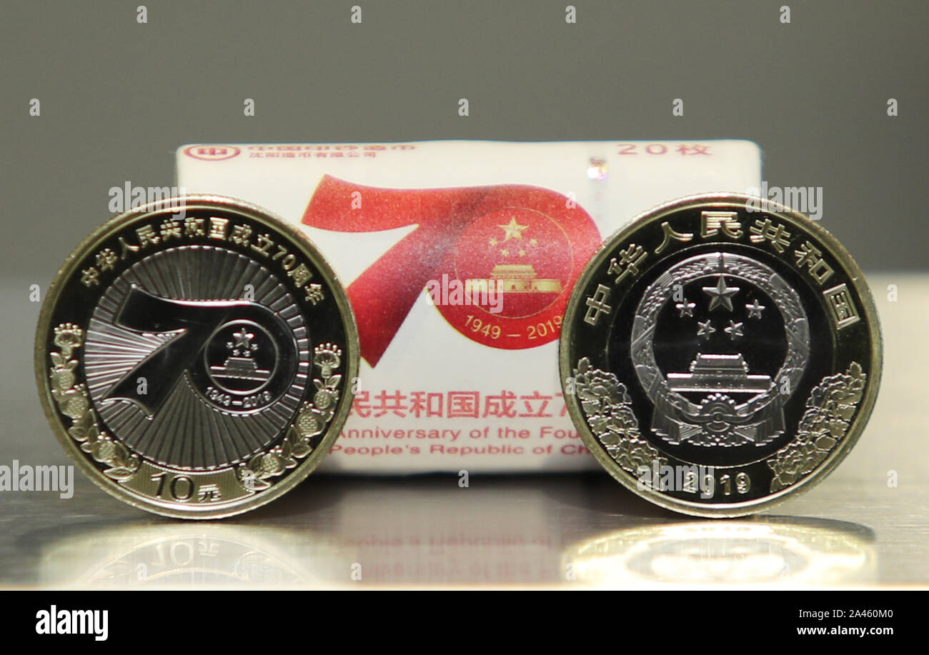 Il neo-lanciato 10 Yuan moneta commemorativa con il tema del settantesimo giorno nazionale della RPC è dimostrato nella città di Kunming, a sud-ovest della Cina di Yunnan pro Foto Stock