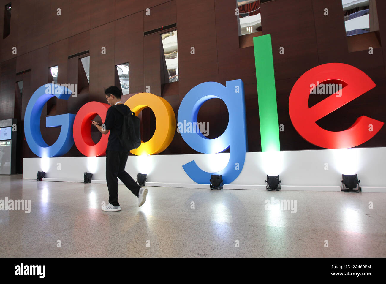 Un ragazzo cammina oltre il logo di Google impostato per il Google agli sviluppatori di giorno in Cina a Shanghai, 10 settembre 2019. Foto Stock