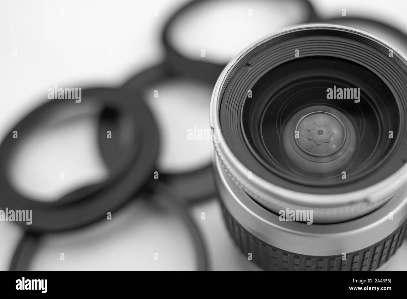 Il diaframma di un obiettivo fotografico dietro la superficie di cristalli, e lo sfondo e sfocata anelli adattativo per lenti Foto Stock