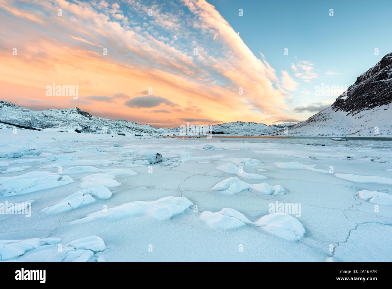 Isole Lofoten in Norvegia e il loro bellissimo paesaggio invernale al tramonto. Paesaggio idilliaco con coperta di neve sulla spiaggia. Attrazione turistica nell'artico ci Foto Stock