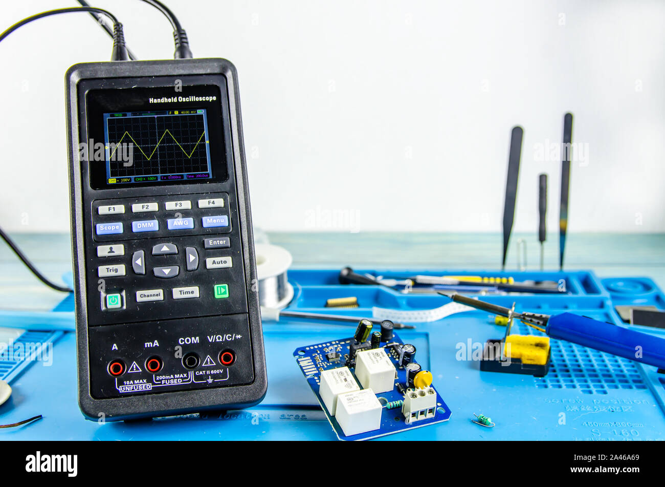 L'elettricista sul posto di lavoro. Elettronica. Regimi di ferro di saldatura. oscilloscopio Foto Stock