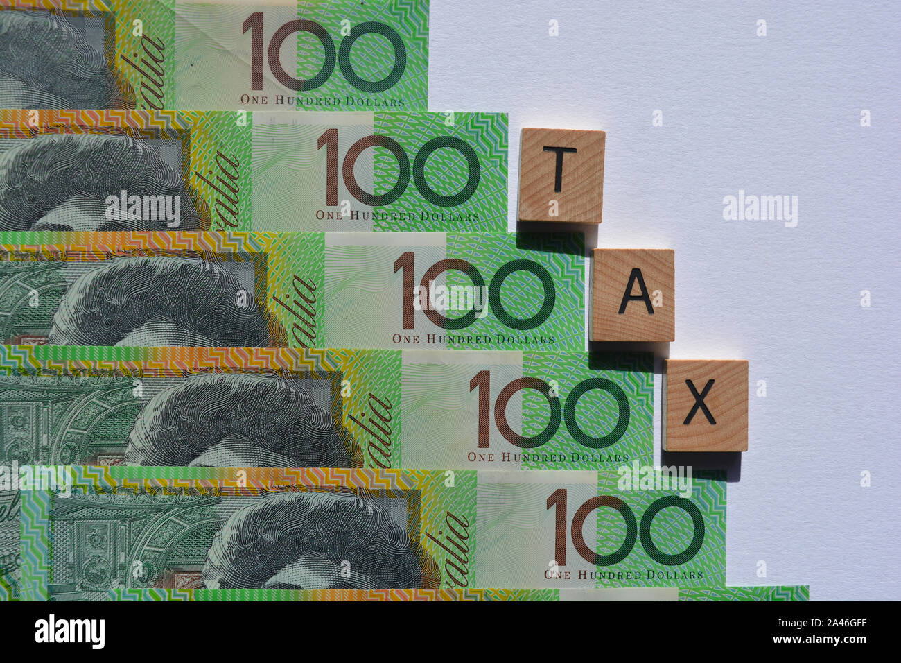 Imposta in 3d alfabeto di legno lettere su uno sfondo di Australian un centinaio di dollari di banconote. Foto Stock