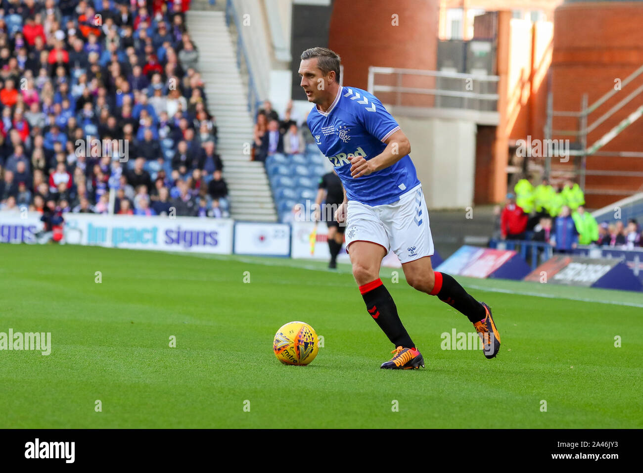 12 ottobre 2019, Ibrox Stadium di Glasgow, UK. Ibrox football Stadium, casa di Glasgow Rangers Football Club ha ospitato una partita tra Rangers leggende (pensionati e ex-giocatori) contro il Liverpool leggende (pensionati e ex-giocatori) con Alex McLEISH (ex Scozia manager) come la mangiatoia dei Rangers e IAN RUSH MBE (ex Liverpool avanti) come il manager del Liverpool. STEVEN GERRARD, che ha giocato per Liverpool e è il manager attuale del Rangers sarà giocare per entrambe le squadre in un qualche momento durante il match. Credito: Findlay / Alamy News Foto Stock