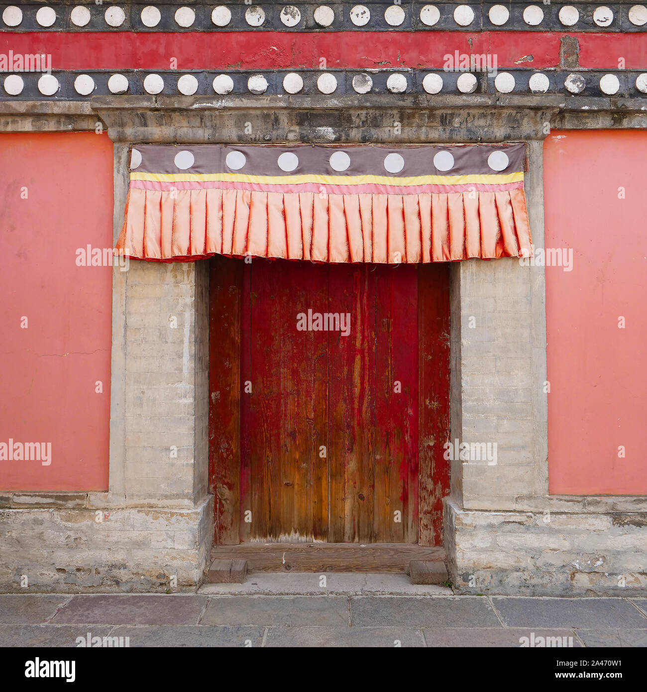 Retrò porta di legno e muro nel monastero Kumbum, Ta'er un tempio del buddismo tibetano monastero nella contea di Huangzhong, Xining Qinghai in Cina. Foto Stock