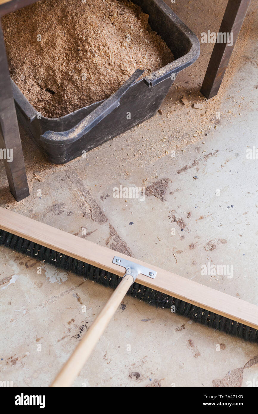 Scopa Sweep workshop, scopa di legno polvere e trucioli di legno del pavimento del workshop Foto Stock