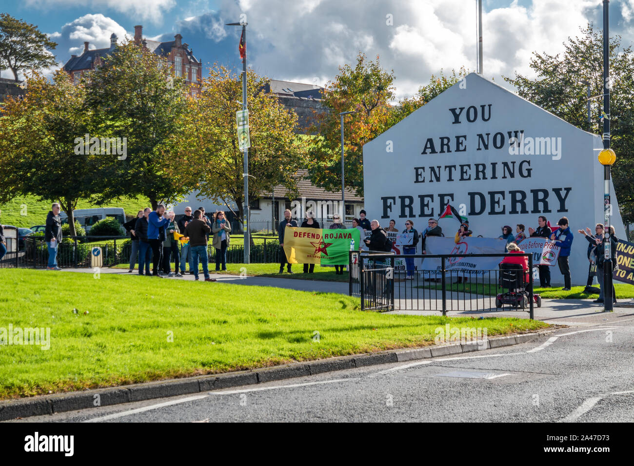 DERRY, Londonderry / IRLANDA DEL NORD - 12 ottobre 2019: persone manifestano contro la guerra davanti al Free Derry monumento. Foto Stock