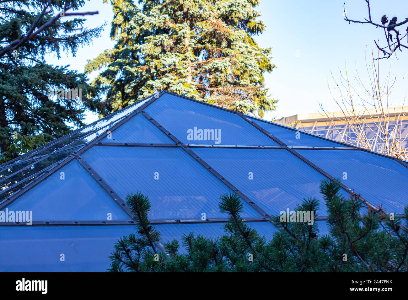 Una a forma di piramide a lucernario finestra appare su una terrazza sul tetto. Il vetro è visibile in ombra, con un più luminoso dello sfondo. Foto Stock