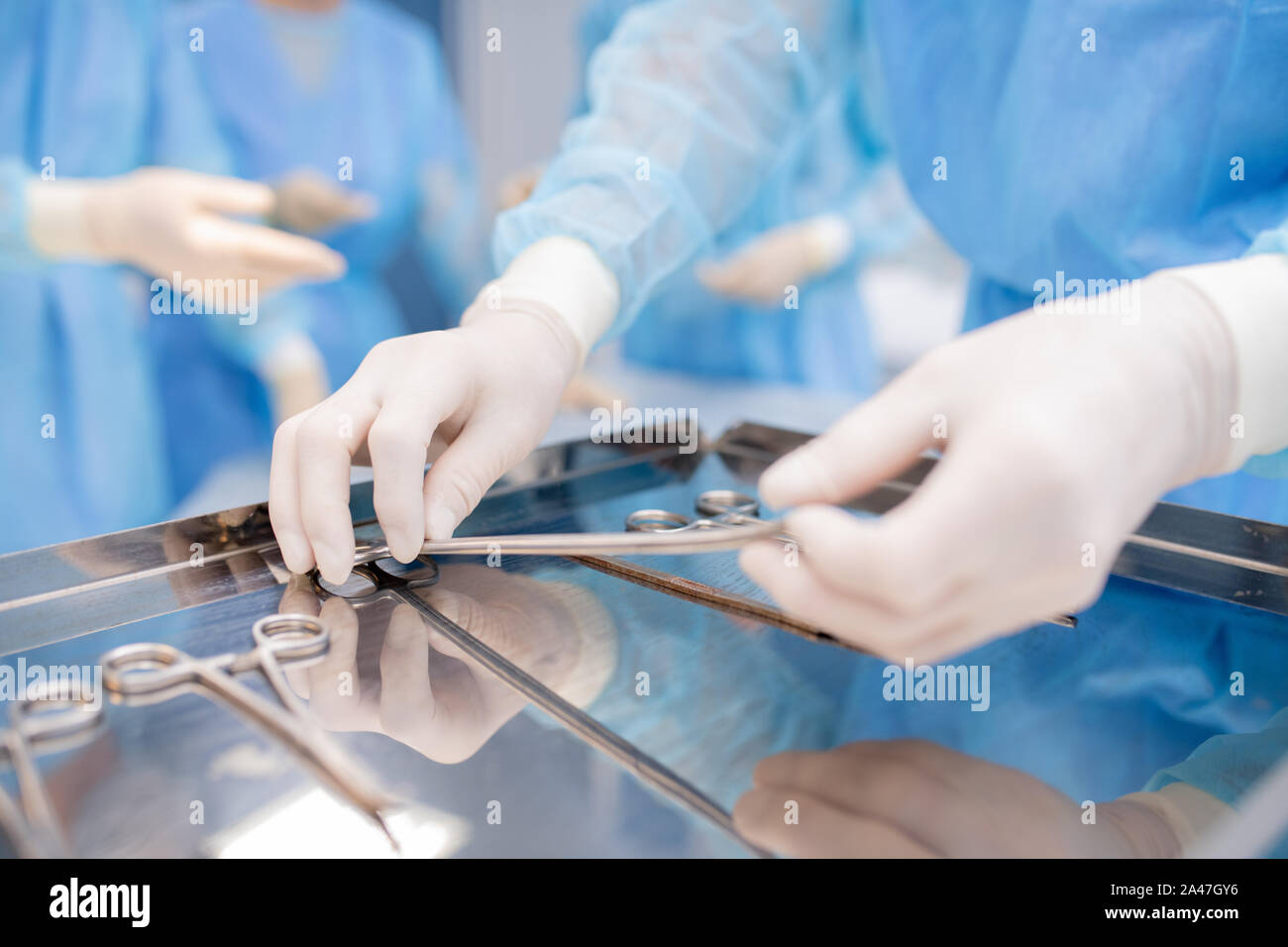 I guanti del chirurgo o assistente prendendo uno degli strumenti sterili Foto Stock