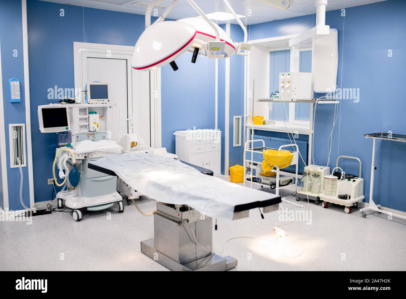 Tabella di funzionamento con grandi lampade al di sopra all'interno contemporaneo sala chirurgia Foto Stock