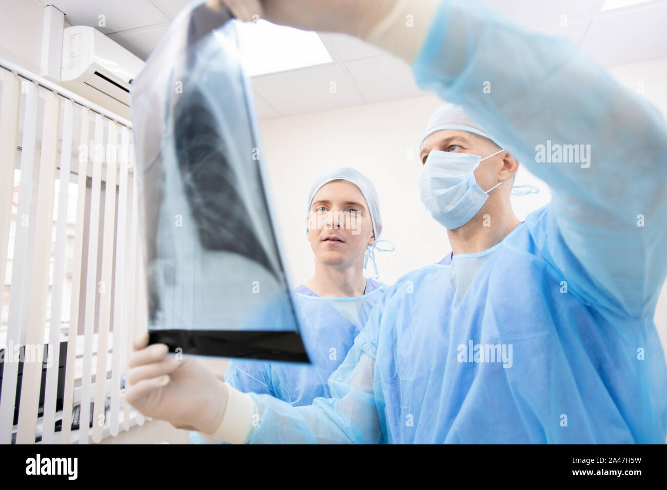 Due professionale pulmonologists in uniforme di protezione cerchi a raggi x dei polmoni Foto Stock