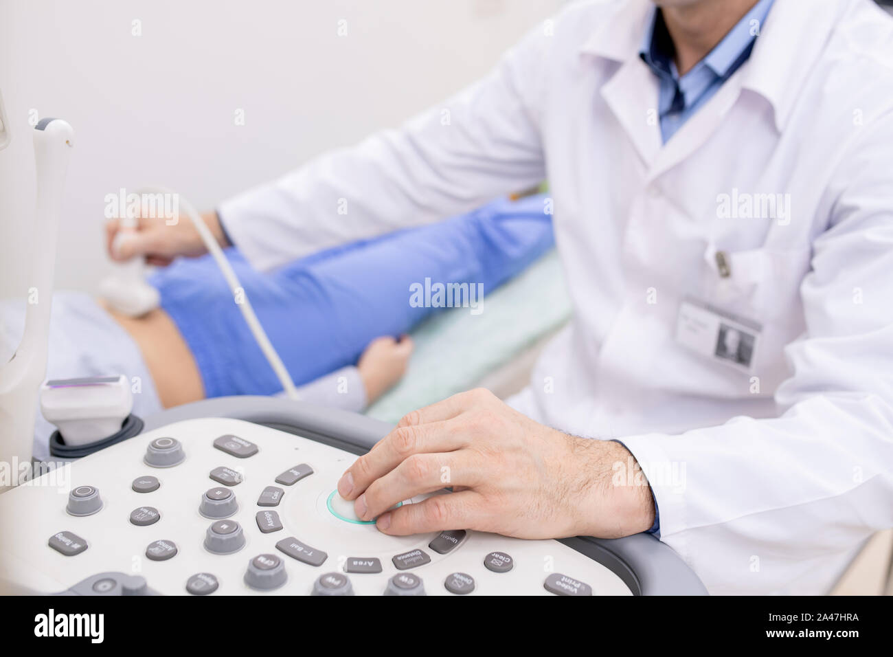 Mano del medico sul pannello di apparecchiature a ultrasuoni durante l'esame Foto Stock