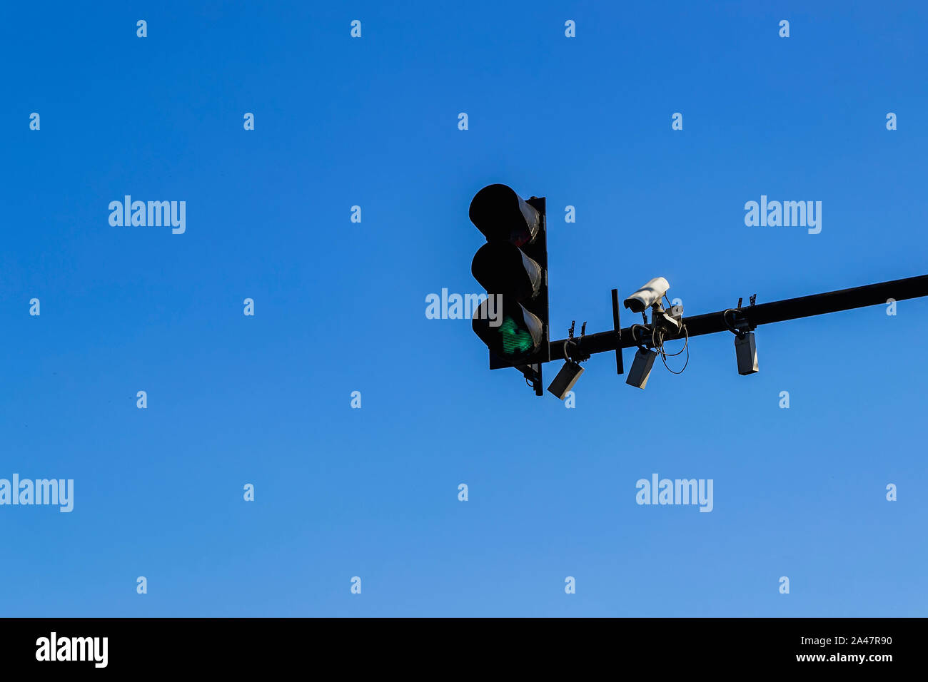 Semaforo con colore verde, outdoor videocamera di sorveglianza e alcuni sensori installati su un palo al di sopra di una carreggiata stradale. Moderni cambi automatici per il controllo del traffico aereo. Foto Stock