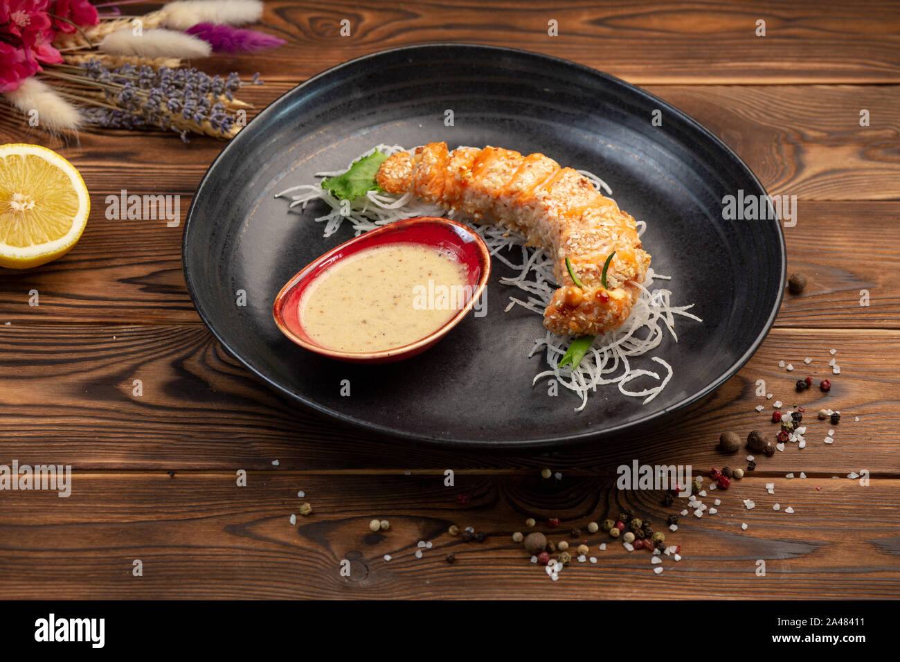 Fette di Salmone cotto nel pane grattugiato con la salsa calda su un cuscino daikon Foto Stock