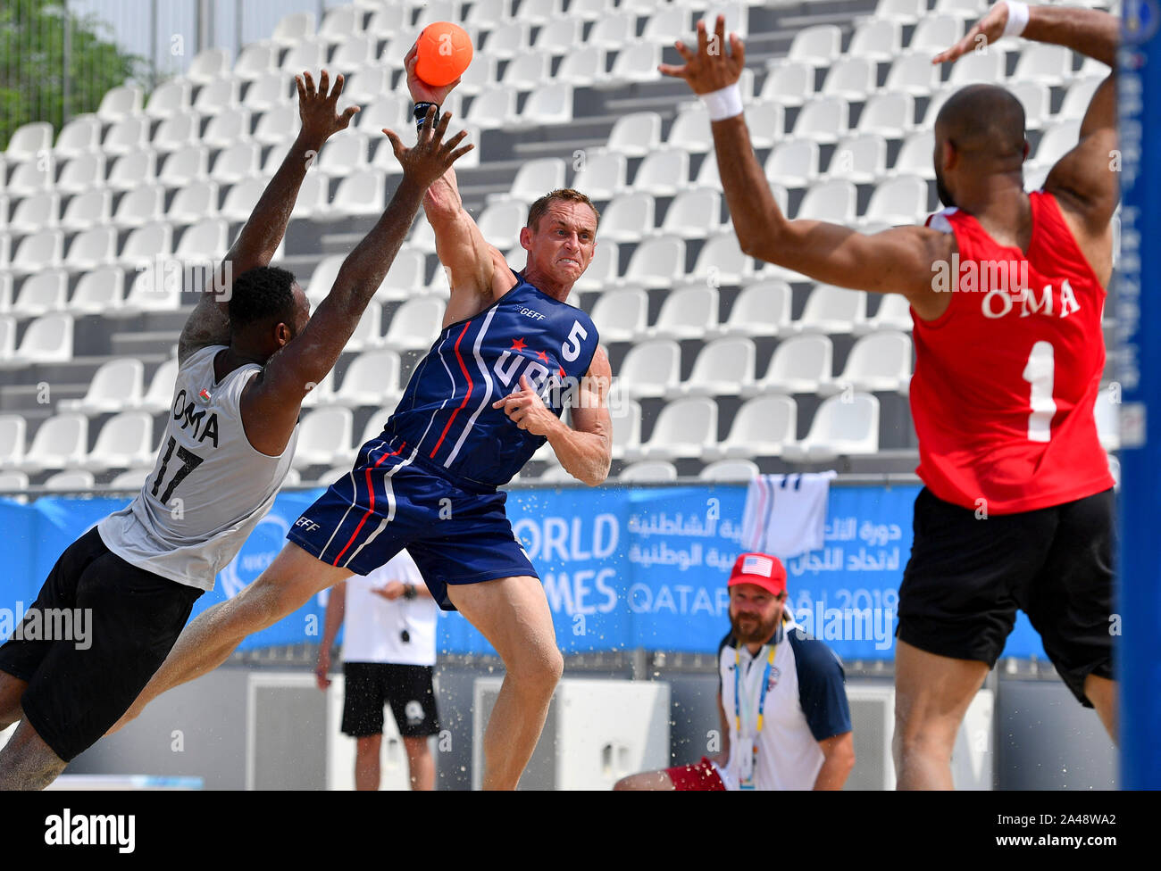 Doha in Qatar. Xii oct, 2019. Charles bianco (C) degli Stati Uniti il sistema VIES con Yasir Al Harthi (L) di Oman durante l'uomo beach handball turno preliminare Gruppo un match tra Oman e gli Stati Uniti al primo mondo ANOC giochi in spiaggia a Doha, capitale del Qatar, Ottobre 12, 2019. Credito: Nikku/Xinhua/Alamy Live News Foto Stock