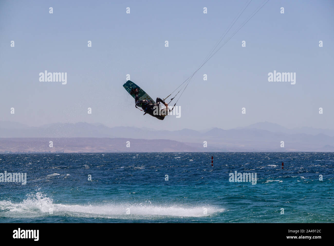 Eilat, Israele - 12 Aprile 2019: avventurosi è uomo di sport acquatici, kite in Mar Rosso durante una giornata di sole. Foto Stock