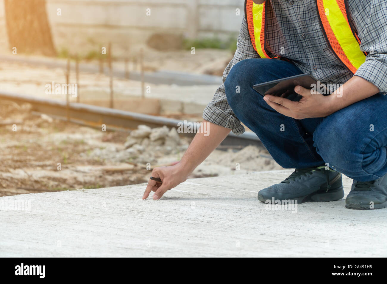 Engineering, che indossa un casco e tenere compresse, sedersi per verificare la struttura del corridoio nel parco Foto Stock