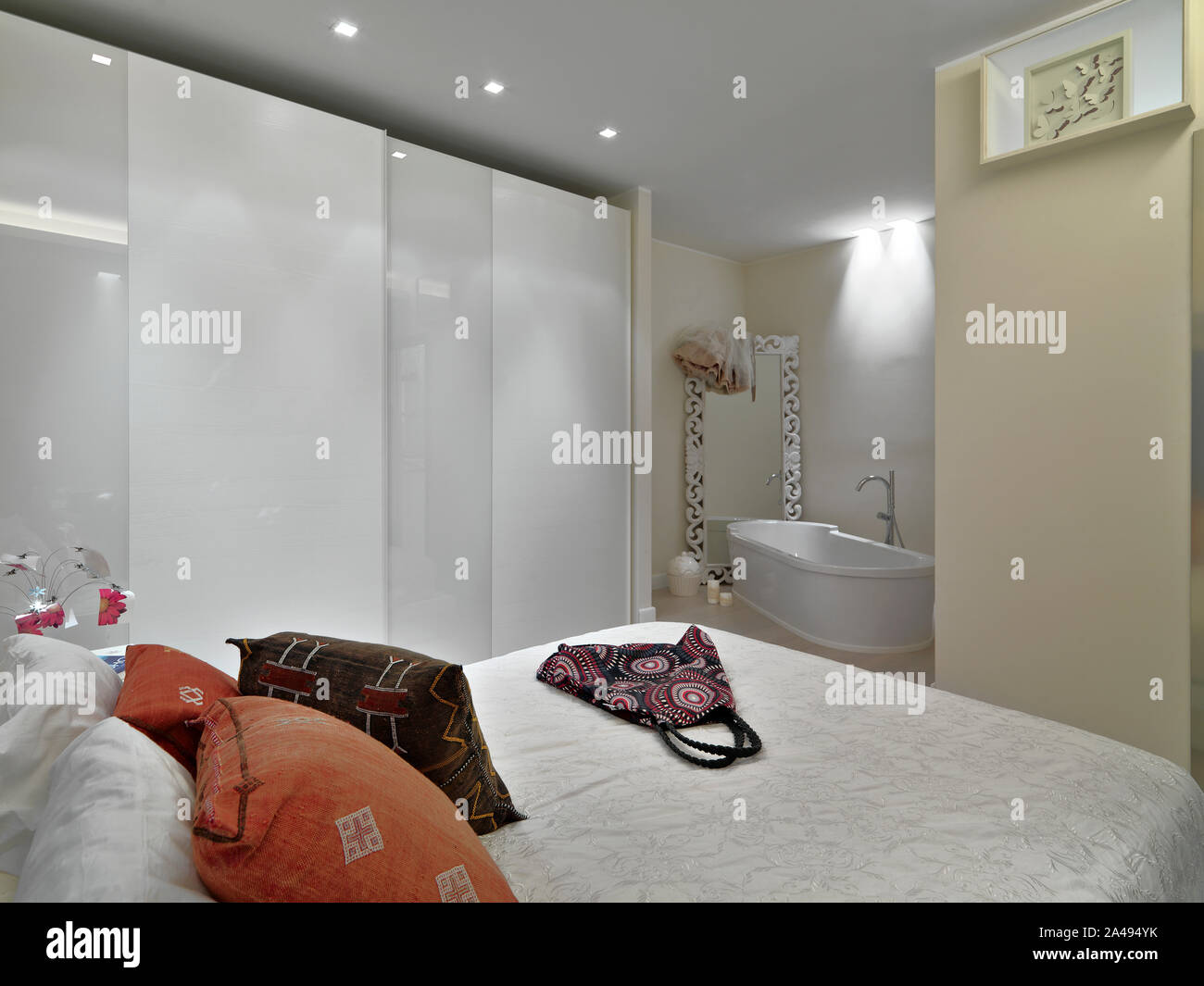 Interior shot di una camera da letto con armadio in background al di là del guardaroba bianco vi è una vasca da bagno indipendente Foto Stock