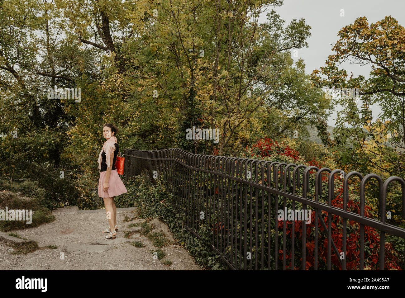 Una ragazza camminare e godere di una soleggiata giornata di caduta in un parco, lifestyle immagine, effetto della pellicola Foto Stock