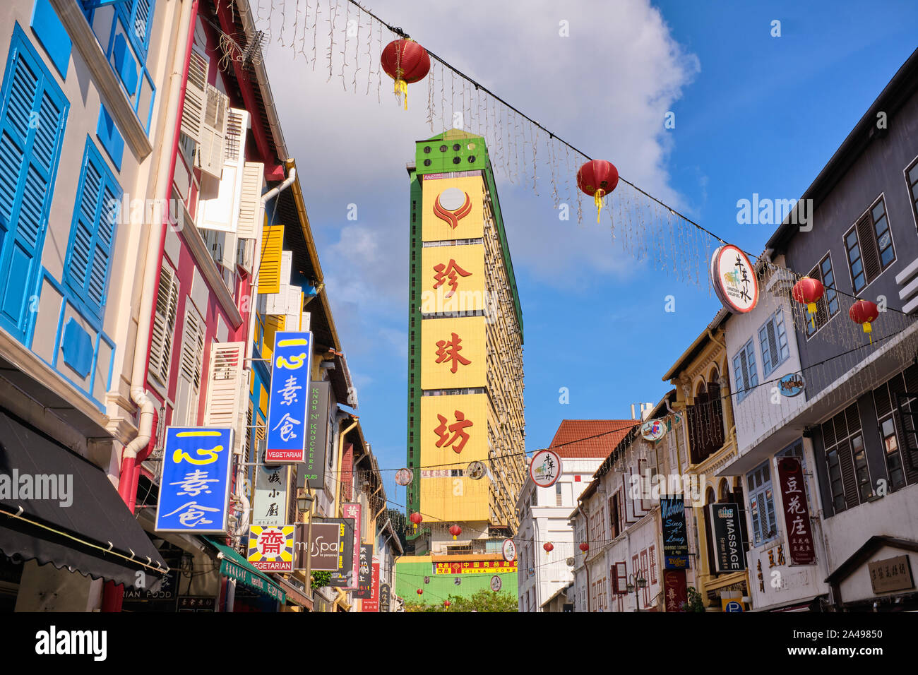 Vista attraverso Temple Street e la sua vecchia, rinnovato botteghe cinesi, a Chinatown, Singapore, verso il punto di riferimento di colore giallo popolare complesso di Parco Foto Stock