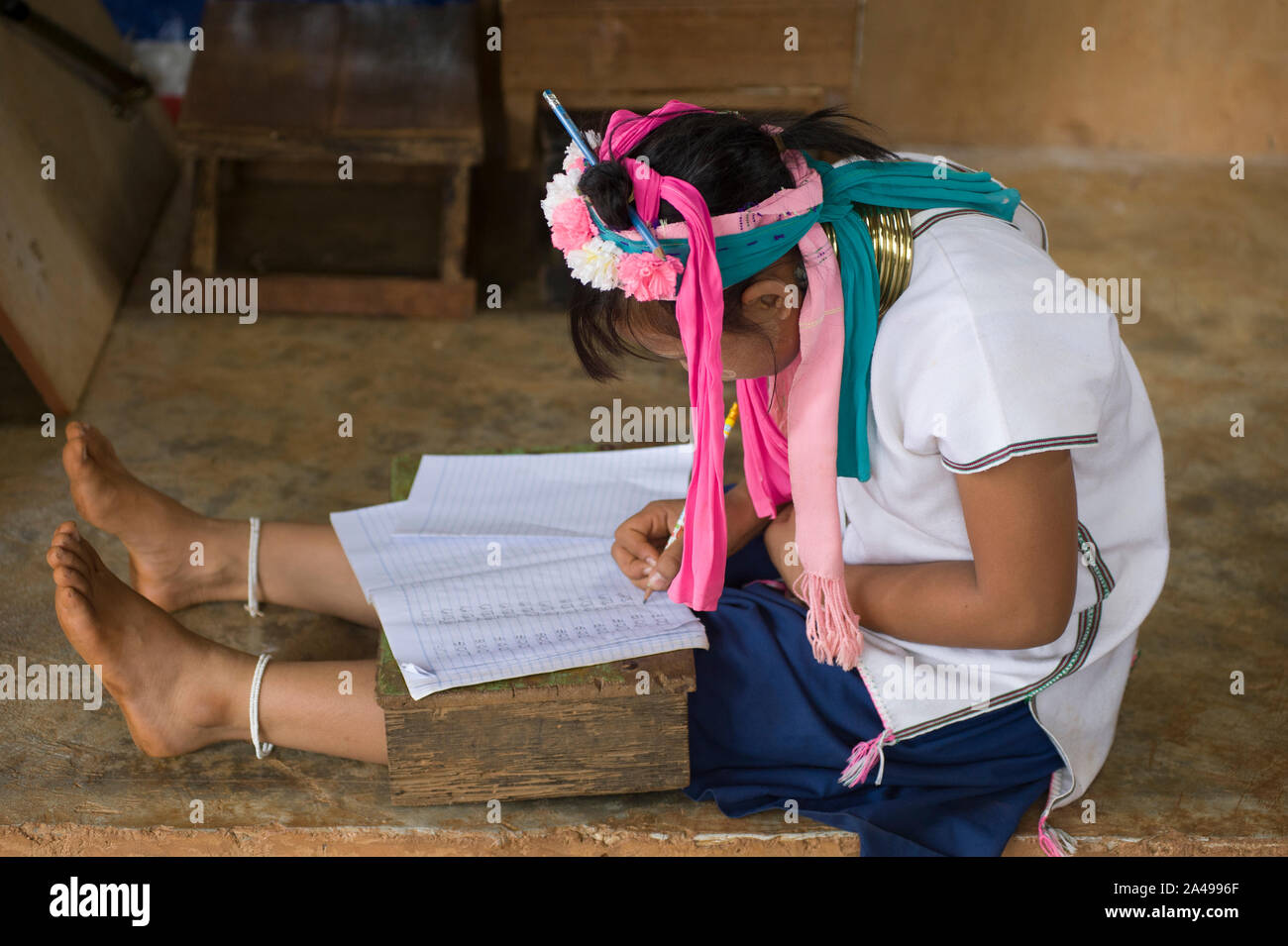 Chiang Rai, Thailandia - Giugno 06, 2011: adolescente studente la ragazza da Kayan lungo collo della tribù della collina la scrittura sul notebook, alla scuola Foto Stock