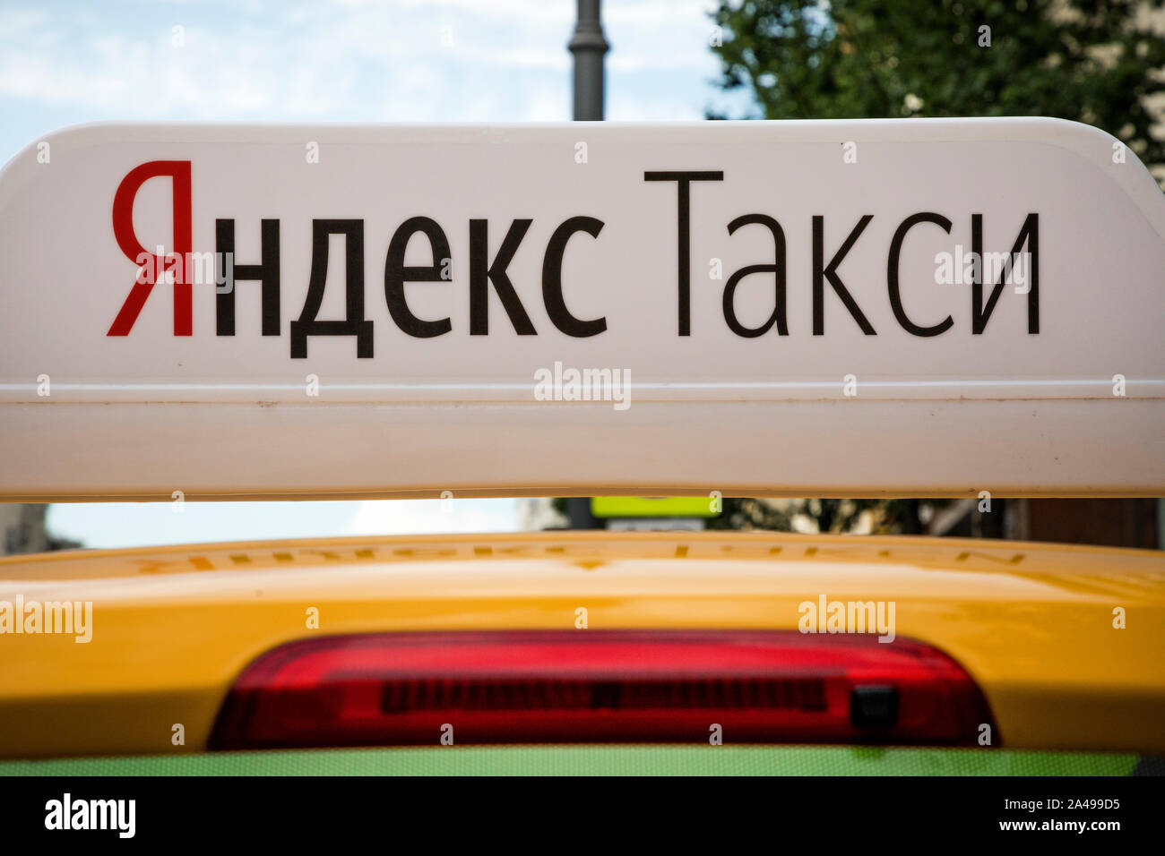 Yellow taxi con banner "Yandex taxi' su un tetto di una vettura in attesa per il passeggero nel centro di Mosca, Russia Foto Stock