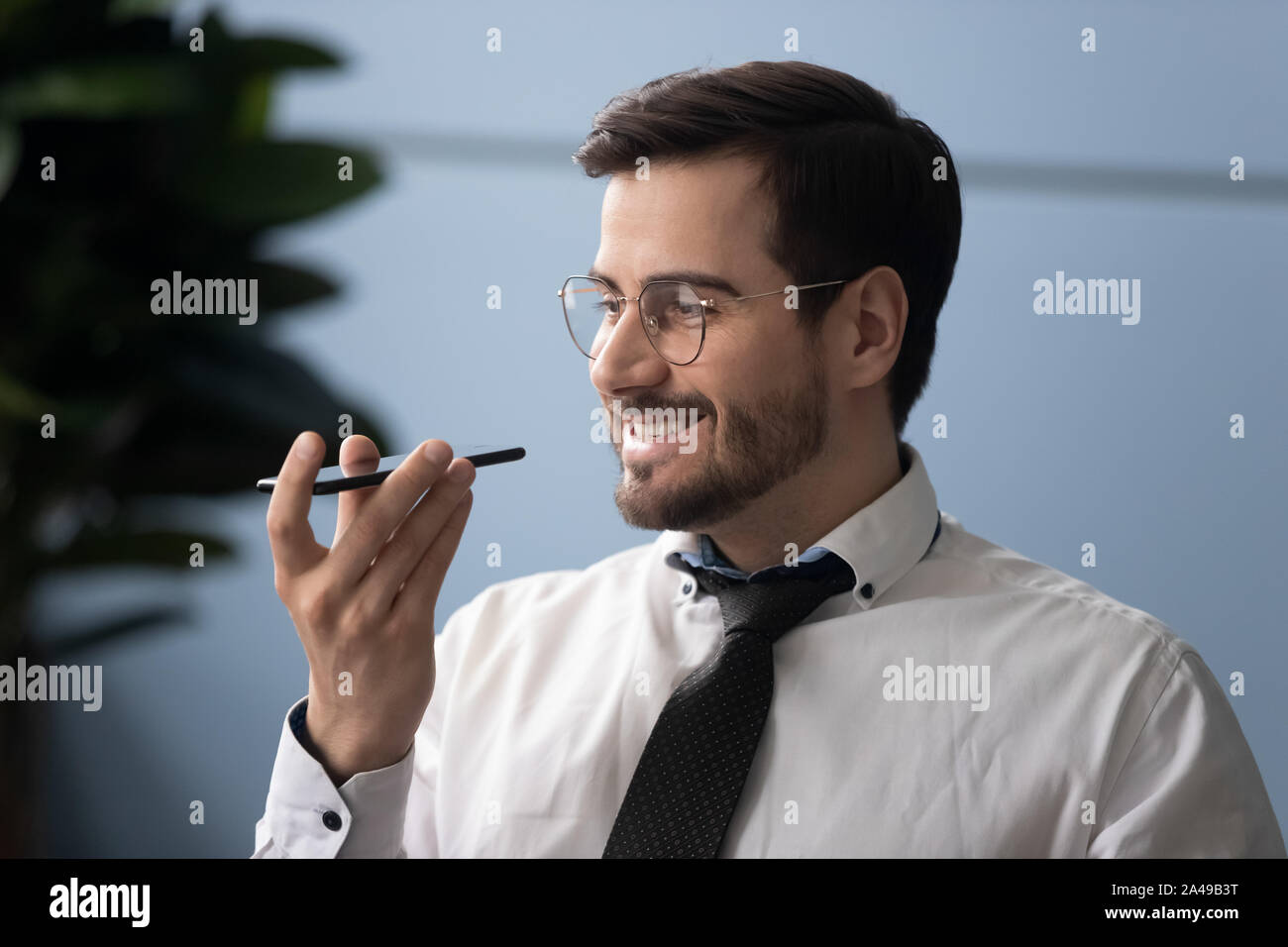 Happy businessman millenaria usando virtual assistant service. Foto Stock
