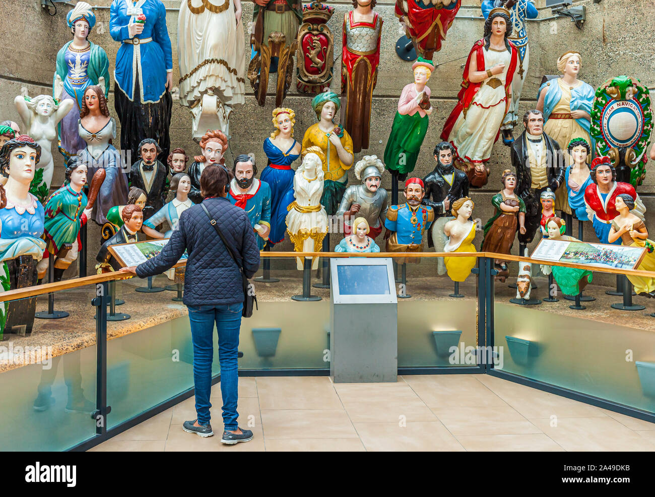 Visitatore guardando la collezione di marina mercantile figureheads figureheads al Cutty Sark Museum, Greenwich. Foto Stock