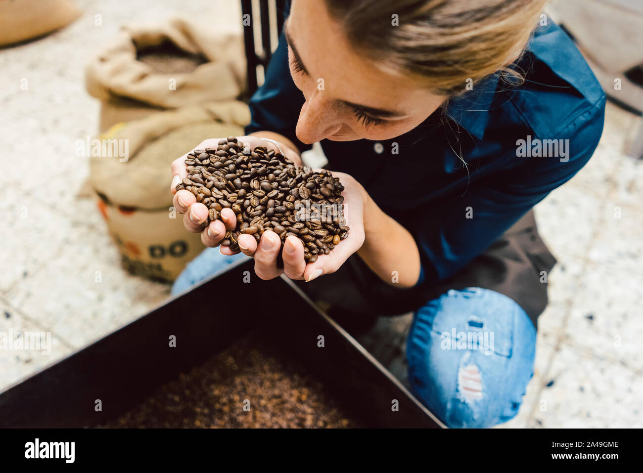 Barista donna test l'aroma del caffè fresco fagioli Foto Stock