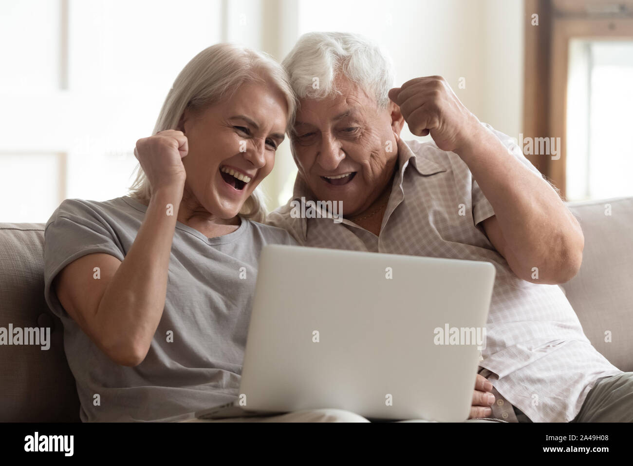 Coppia di anziani urlare di gioia celebrando la vittoria della lotteria momento fortunato Foto Stock