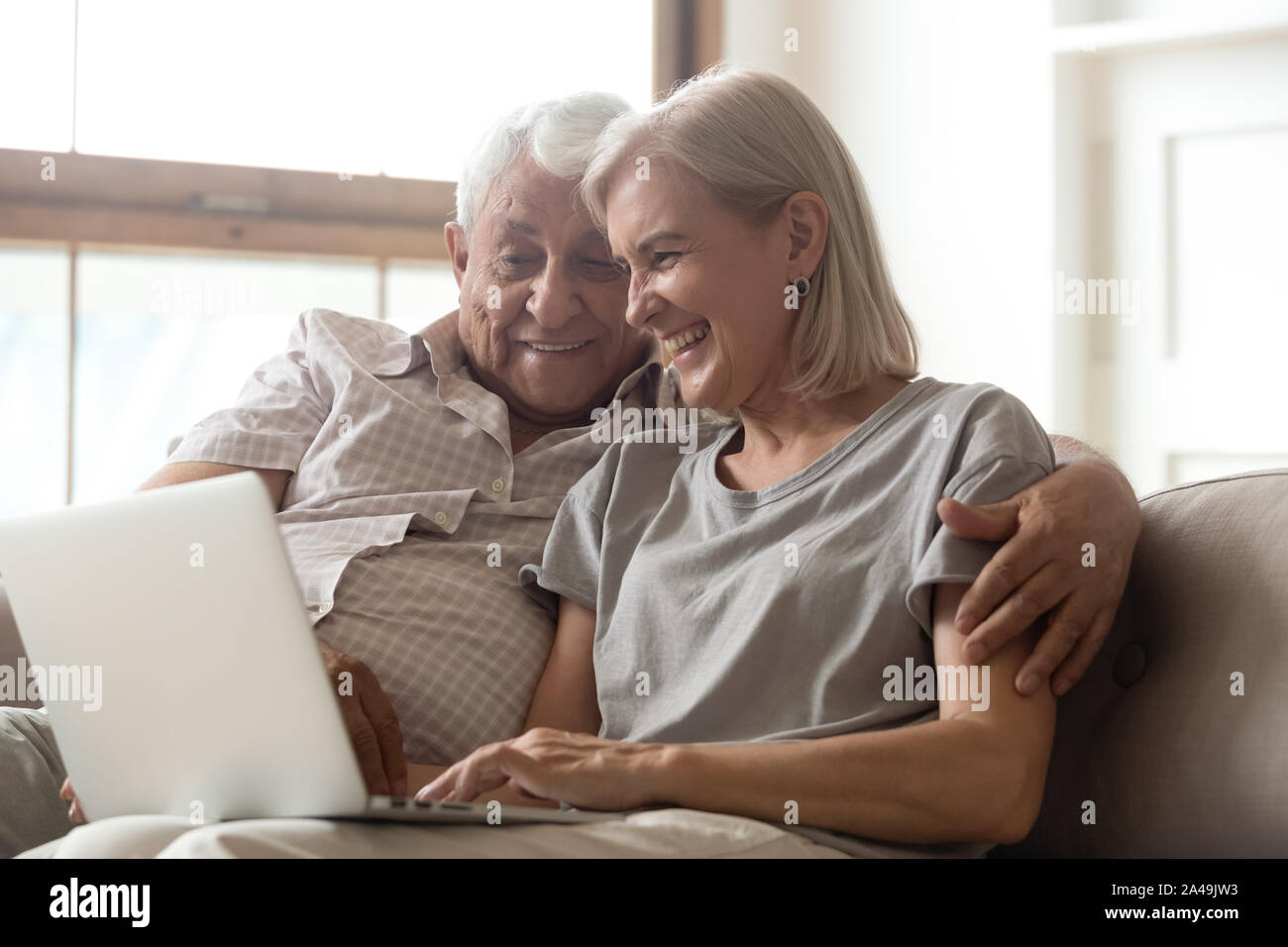 Vecchio marito e moglie utilizzando laptop in chat con bambini cresciuto Foto Stock