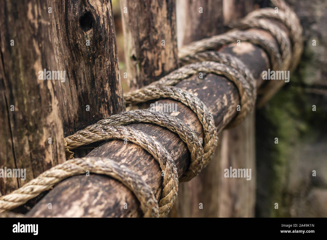 La vecchia staccionata in legno è legato per la durata con funi, bello e sicuro. Close-up. Foto Stock