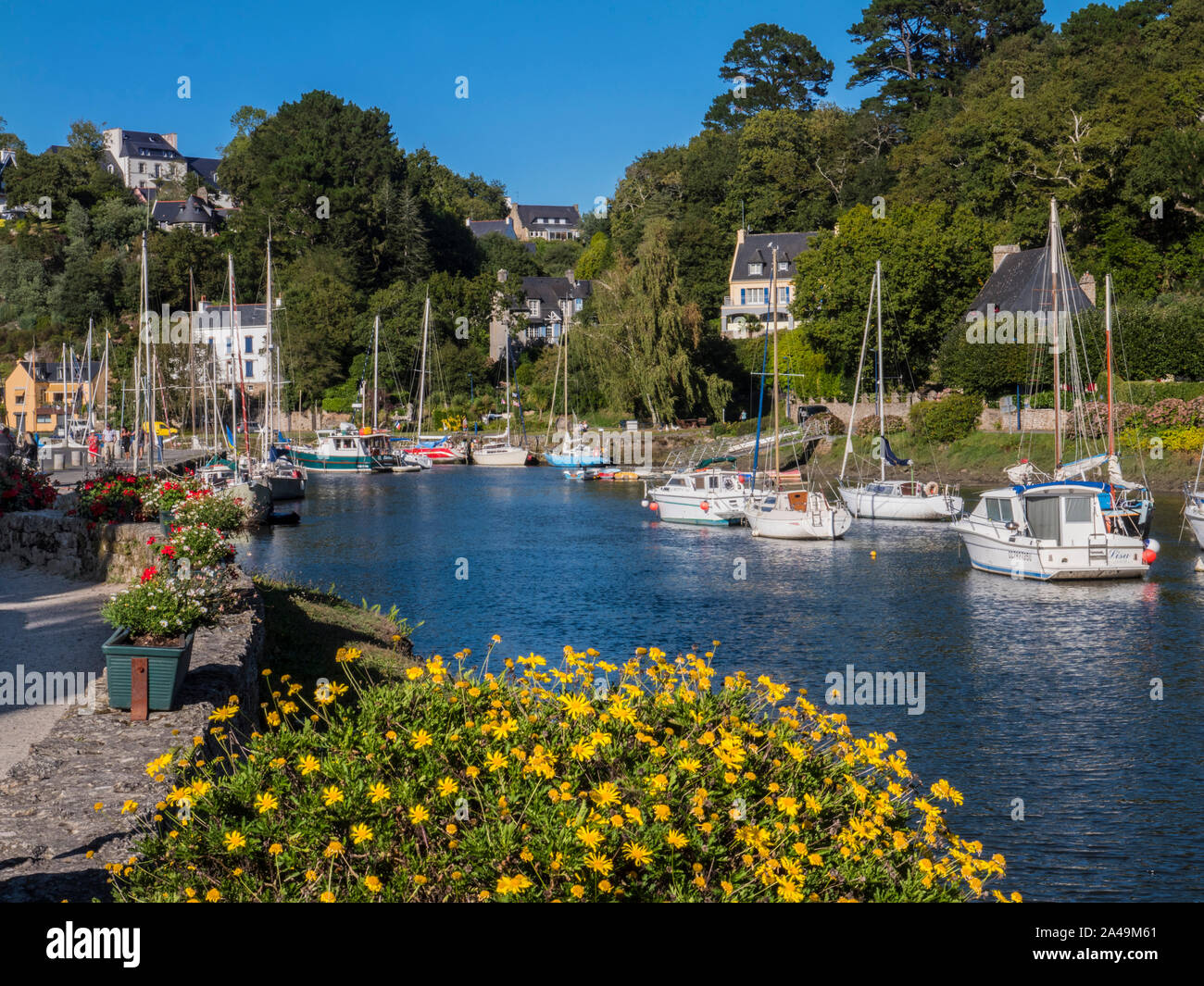 Pont-Aven Brittany floral sunny scena di paesaggio con barche a vela e le case sulle rive del fiume Aven dipartimento di Finistère Bretagna Francia Foto Stock