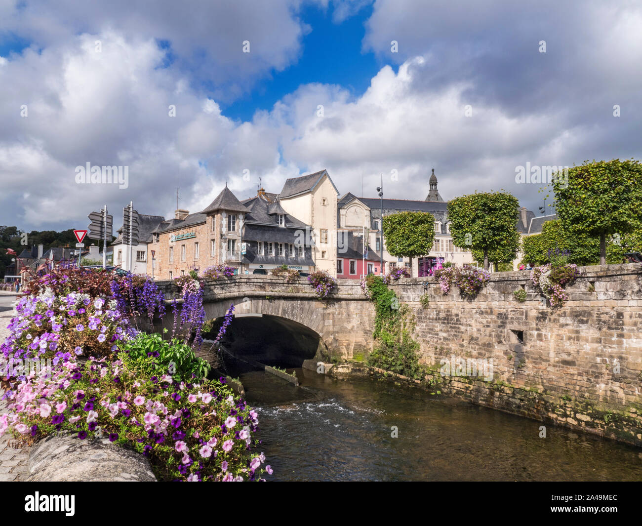 Quimperlé Brittany Finisterre Francia sul fiume Laita con ponte e fiori in primo piano e drammatico cielo di autunno a nord ovest della Francia Foto Stock