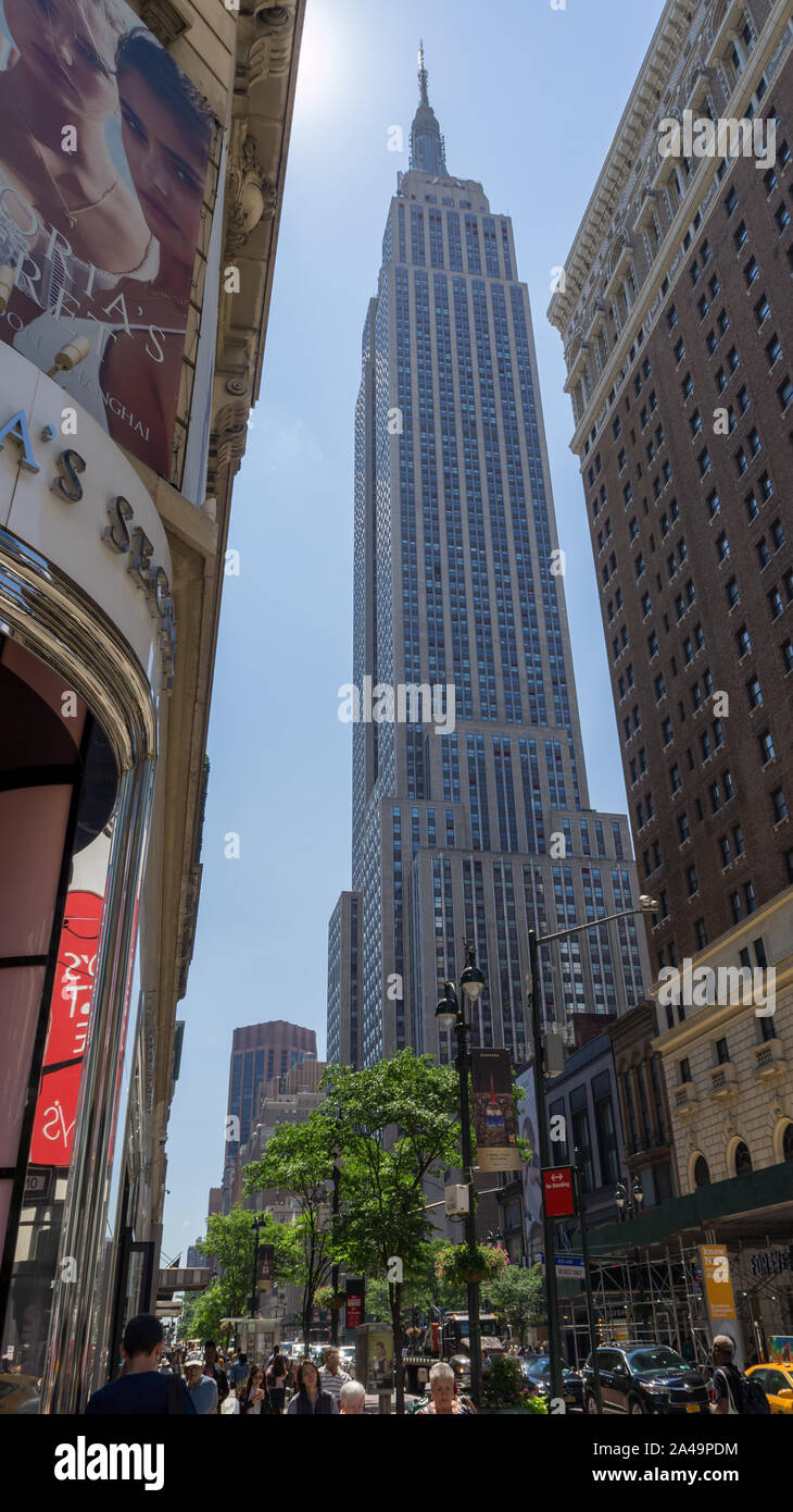 Montante colpo di Empire State building visto dal livello del suolo, schiacciato tra due edifici Foto Stock