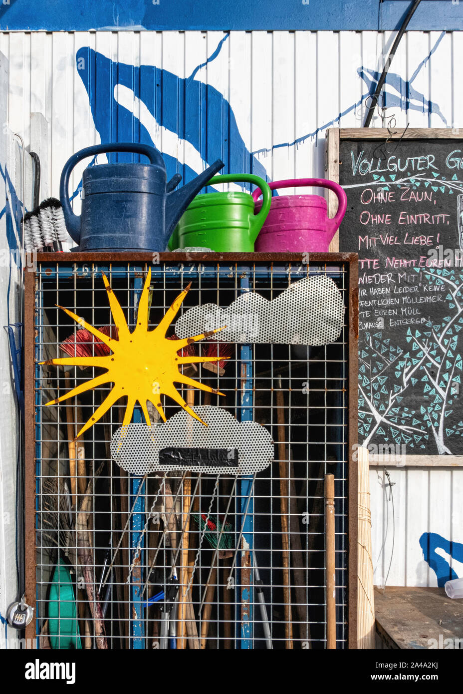 Vollguter comunità giardino. Bizzarre Tettoia da giardino, attrezzature da giardino, innaffiatoi - spazio esterno per tutti in Neukolln, Berlino. Foto Stock