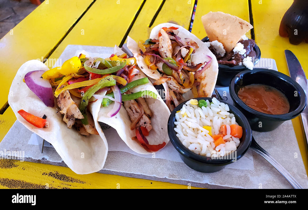 Pollo fresco tacos servita su tortilla di farina con refried fagioli e riso Foto Stock