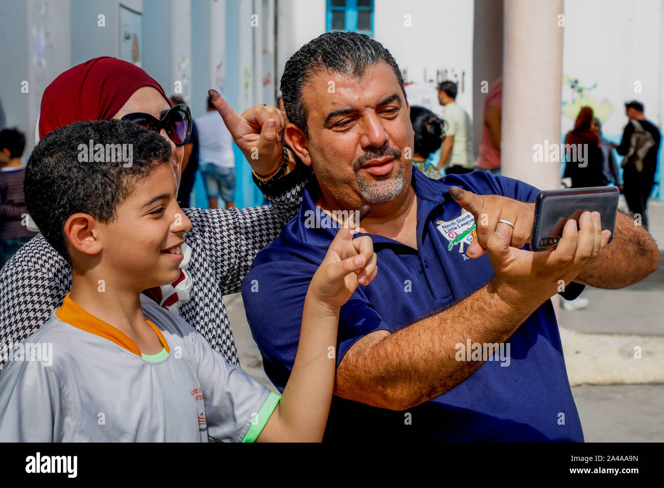 Tunisi, Tunisia. Xiii oct, 2019. Una famiglia prende un selfie mostrando le loro dita inchiostrato dopo la colata i loro voti in corrispondenza di una stazione di polling durante il secondo turno delle elezioni presidenziali tunisino tra candidati presidenziali Kais Saied e Nabil Karoui. Credito: Khaled Nasraoui/dpa/Alamy Live News Foto Stock