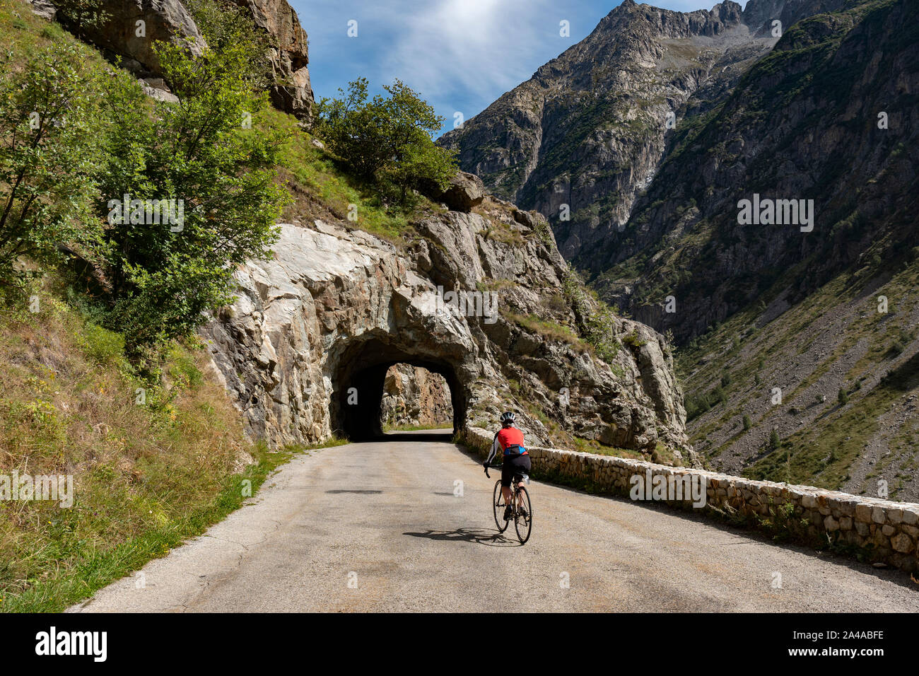 Femmina matura ciclista in sella alla strada tranquilla fino ti Saint Christophe Oisans, Alpi occidentali,Francia. Foto Stock