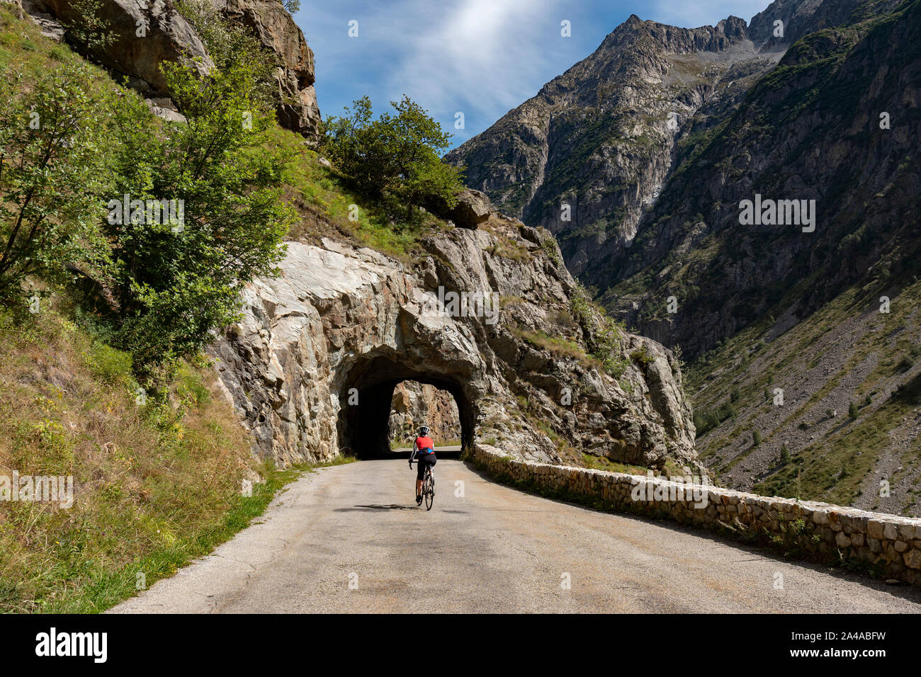 Femmina matura ciclista in sella alla strada tranquilla fino ti Saint Christophe Oisans, Alpi occidentali,Francia. Foto Stock