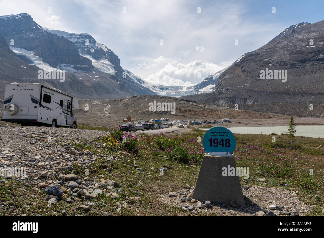 Il Columbia Icefield, Canada - Agosto 10, 2019: la strada per il ghiacciaio con rimorchi e firmare per dimostrare il restringimento del ghiacciaio Foto Stock