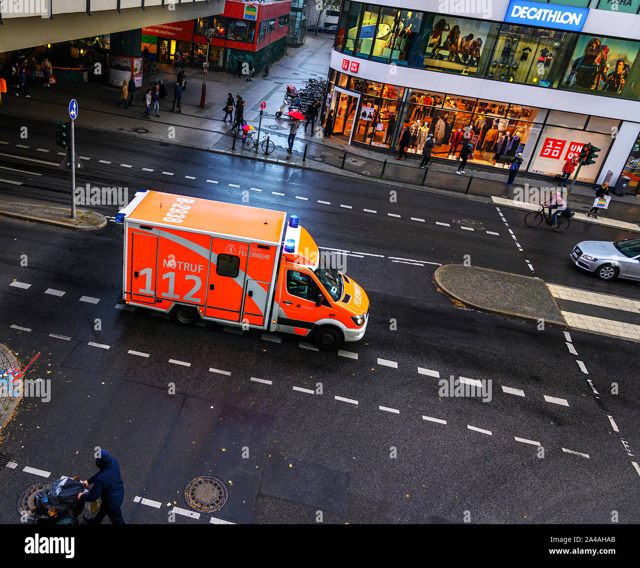 Berlino, Germania - 5 Ottobre 2019: ambulanza dei vigili del fuoco in una trafficata via dello shopping in Berlin-Steglitz in condizioni di tempo piovoso durante una missione dri Foto Stock
