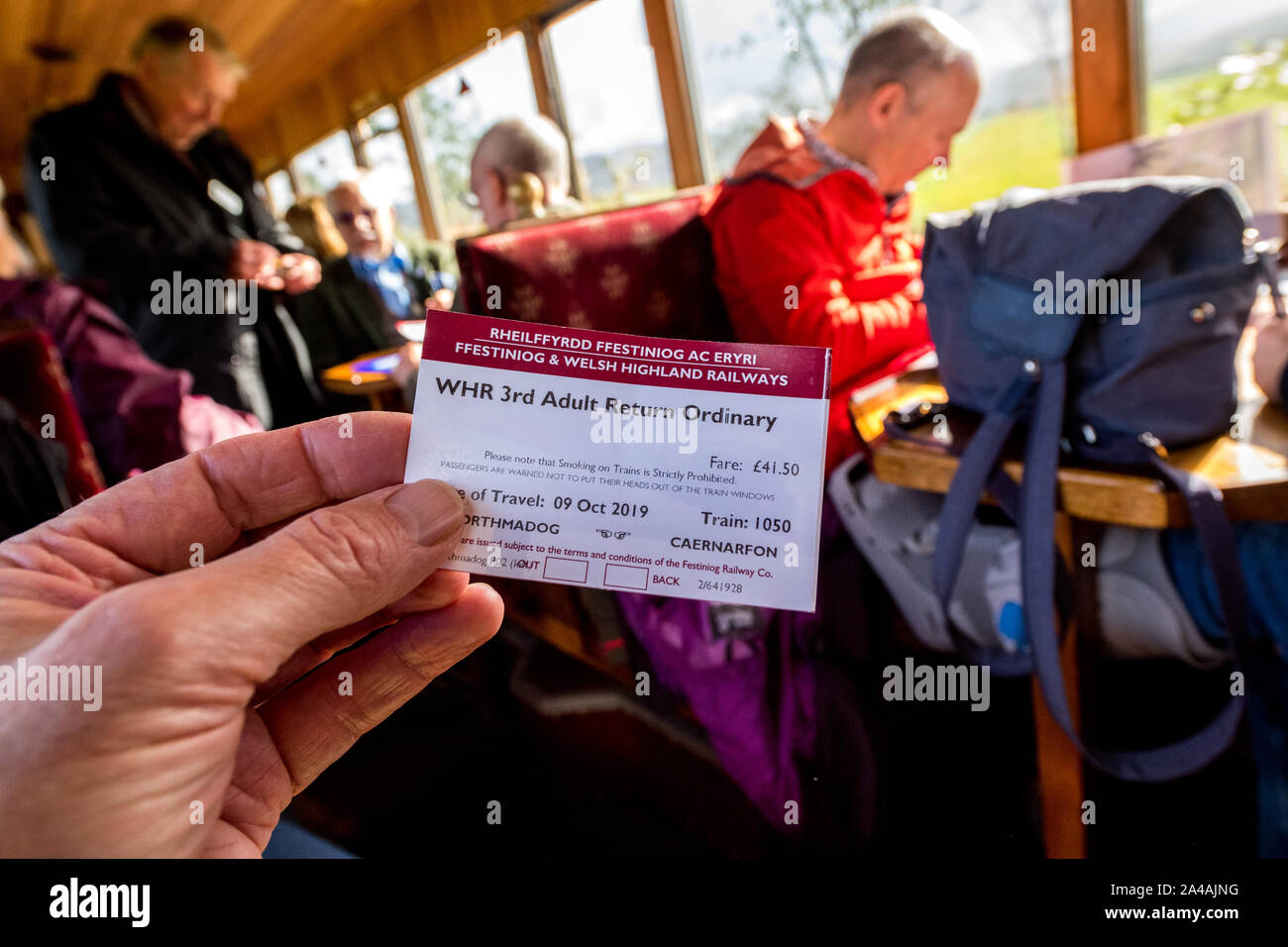 Passeggero in possesso di un datato biglietto ferroviario all'interno di una rampa coach sul Ffestiniog & Welsh Highland Railway. Foto Stock
