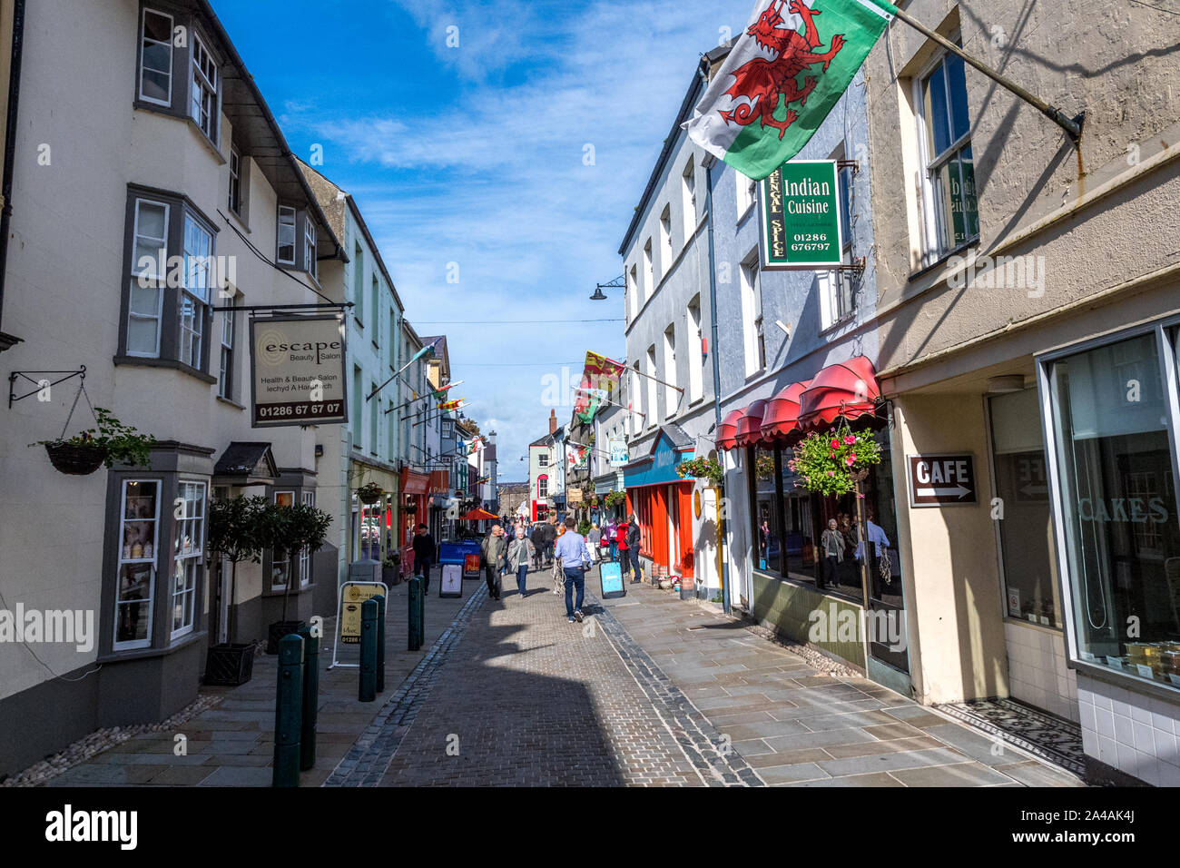 Palace street a Caernarfon, Galles. Una trafficata strada di ciottoli di negozi e ristoranti nel centro della città. Foto Stock