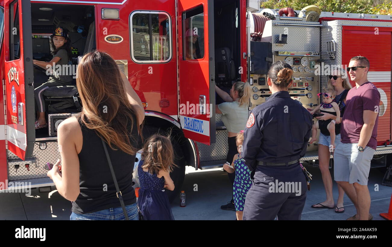 Famiglie si incontrano i soccorritori ed esplorare il fuoco di camion alla stazione di fuoco open house Foto Stock