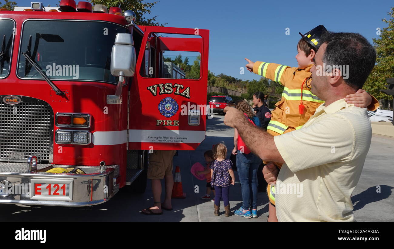 Famiglie si incontrano i soccorritori ed esplorare il fuoco di camion alla stazione di fuoco open house Foto Stock