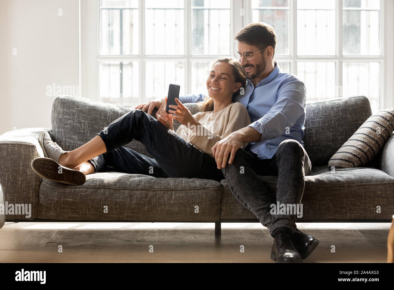 Coppia felice in amore rilassante sul lettino insieme, tramite cellulare Foto Stock